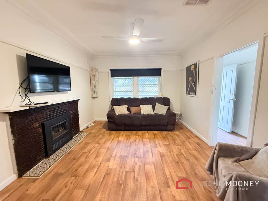 Bright living room featuring a fireplace, TV, and comfortable sofa in a welcoming home.